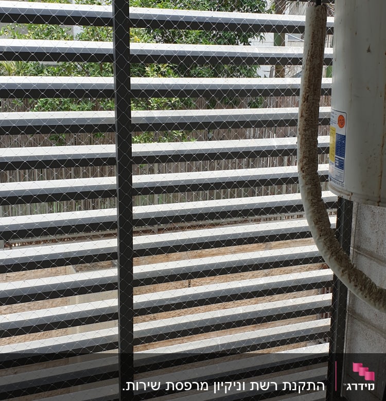 רשת מתכת על חלון למניעת כניסת יונים